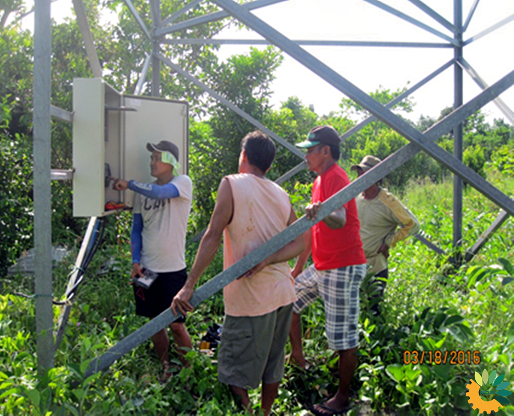 Local technicians checking on the controls of the solar pumping system.