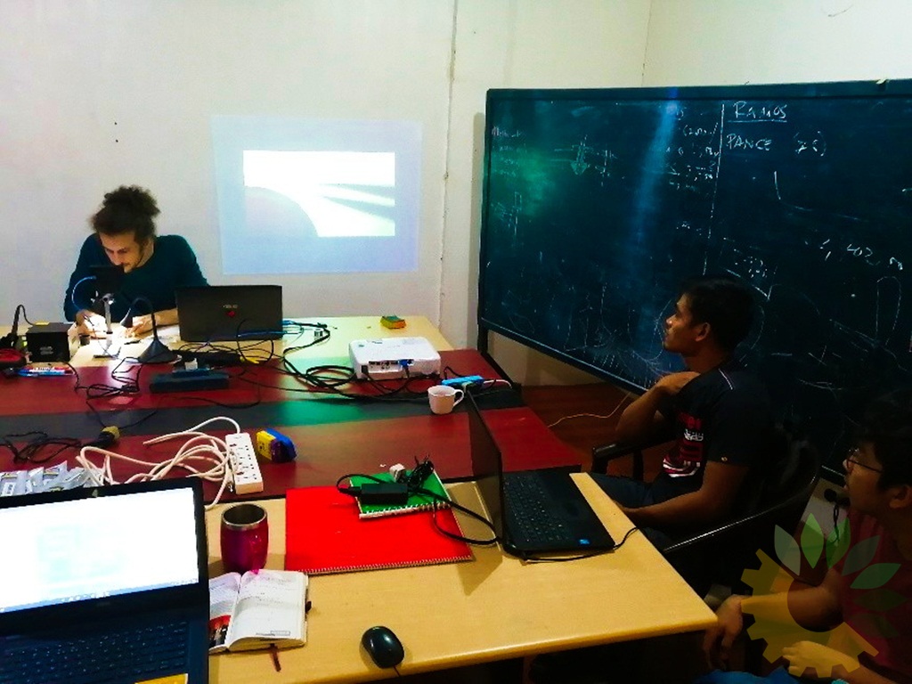 Engr Dan Frydman demonstrating assembly of micro electronic parts to the electronic boards via a microscope connected to a laptop and projected on the wall.